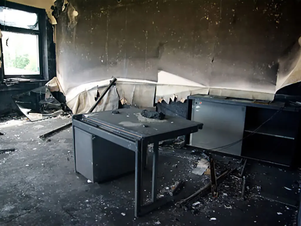 a room that has been damaged by fire with daylight shining through the window