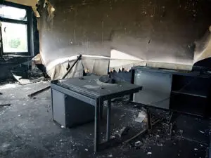 a room that has been damaged by fire with daylight shining through the window