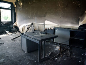 a room that has been damaged by fire with daylight shining through the window